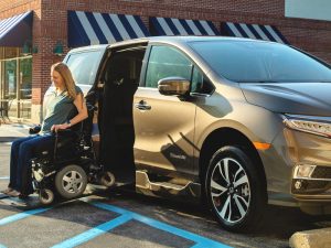 Wheelchair user exiting a parked Honda Odyssey wheelchair van.